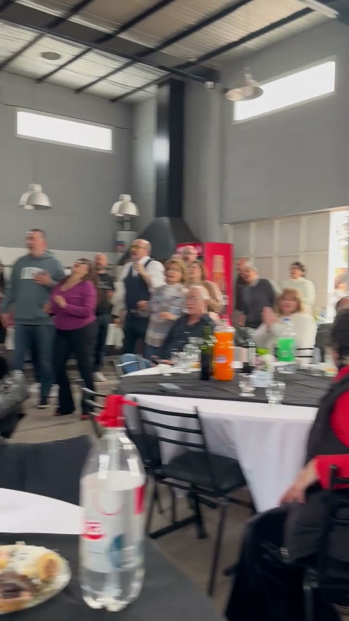 Invitados bailando y cantando con las manos arriba